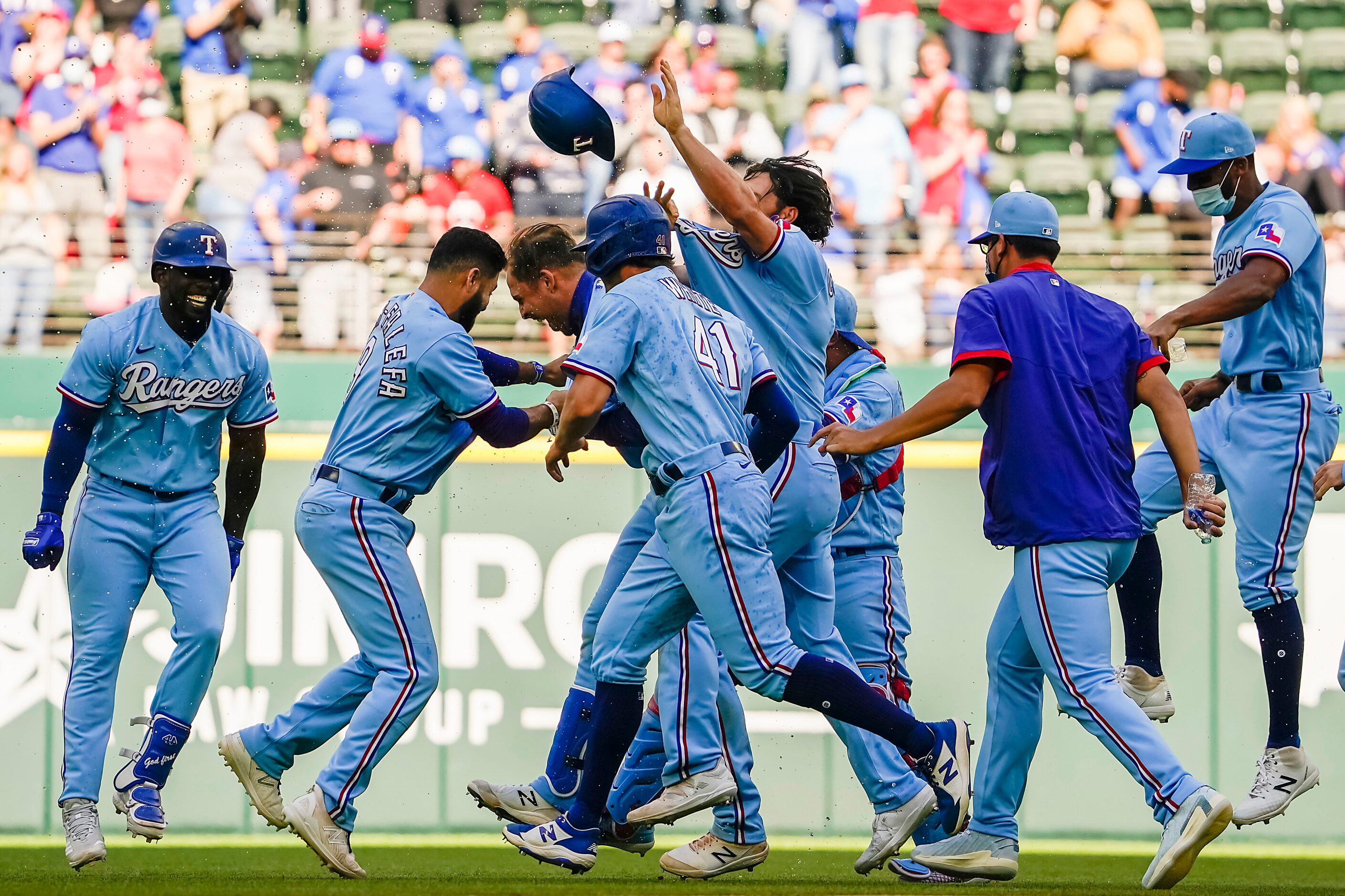 Texas Rangers first baseman Nate Lowe is mobbed by teammates after hitting a walk-off single...