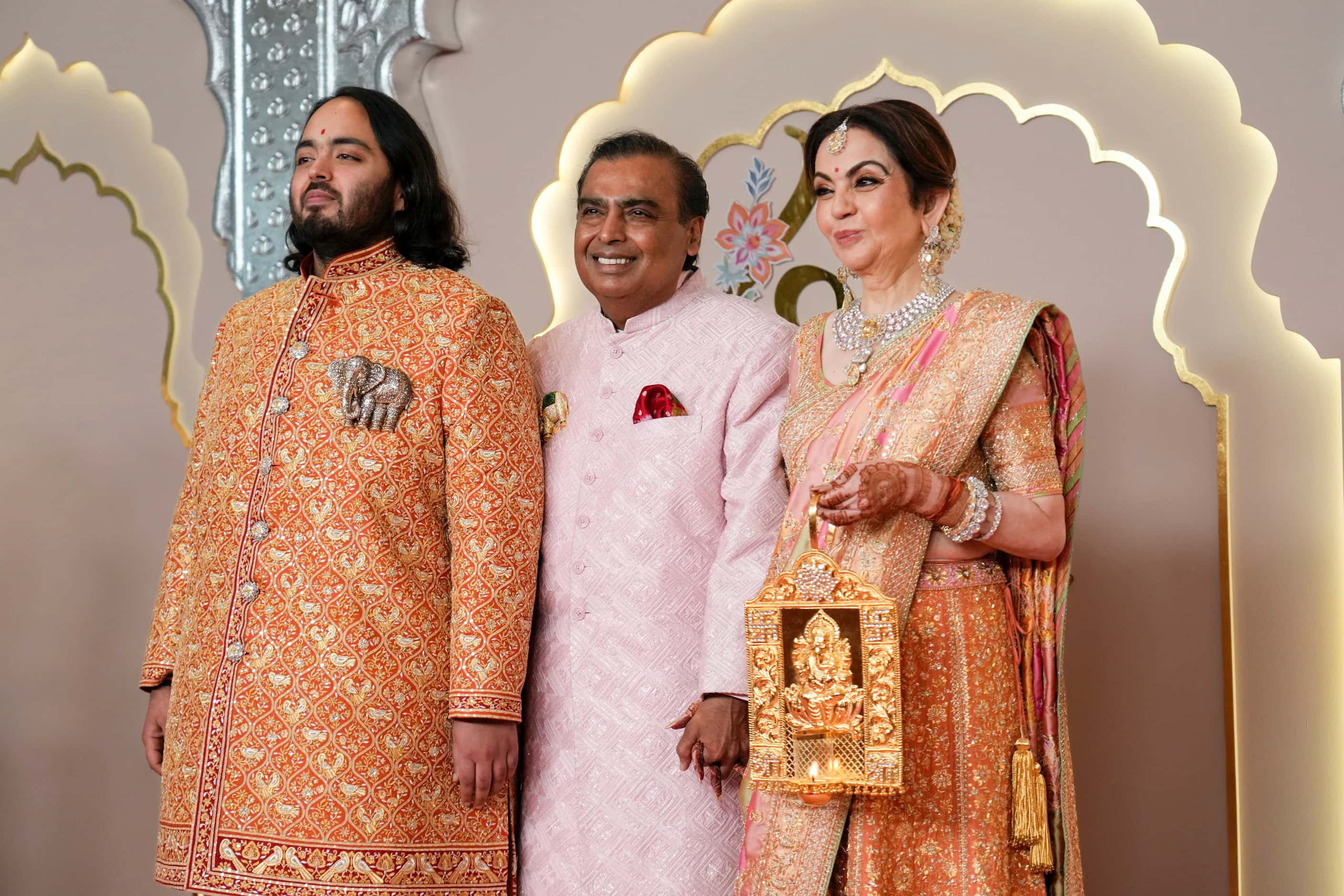 Billionaire Mukesh Ambani, center, with son Anant, and wife Nita 
