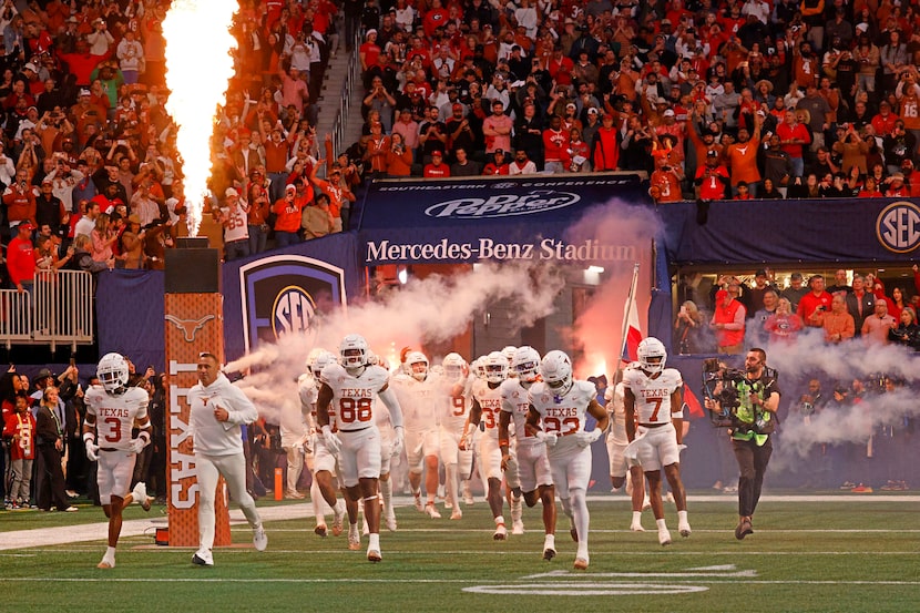 Texas head coach Steve Sarkisian and his players run out to the field before  the...