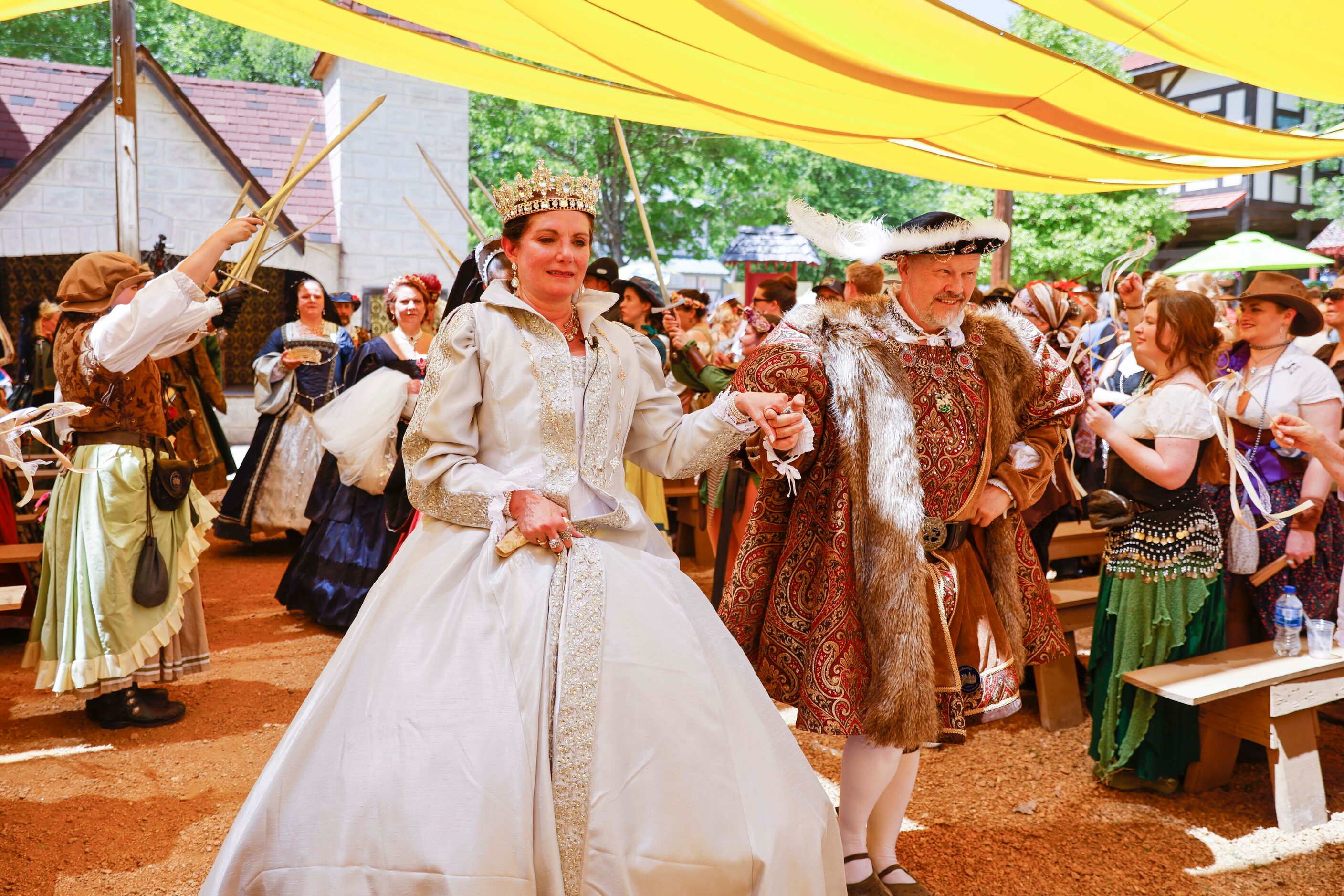 Janna Zepp, playing Queen Catherine Parr, and Mick Moreau playing King Henry VIII, walk...