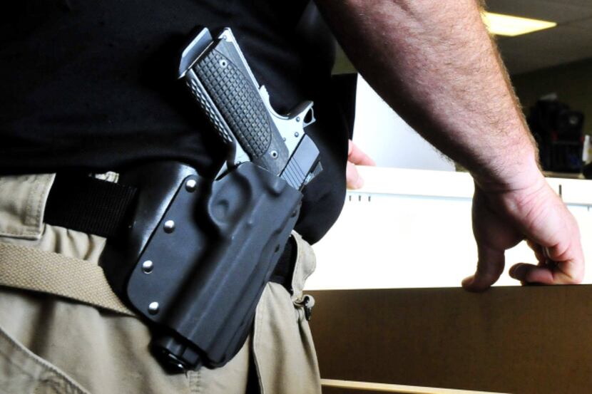 Stillwater Armory owner Tom Smith wears his Ed Brown 1911 .45-caliber pistol at the store in...