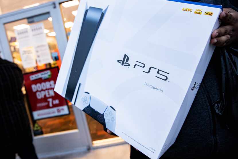 Brandon Lopez of Irving hold his Playstation 5 after waiting in line since 10 a.m. yesterday...