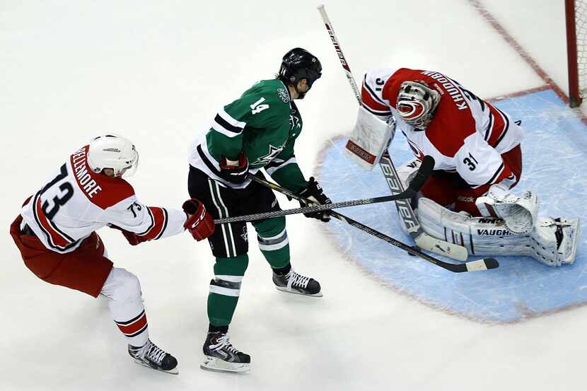 Dallas Stars left wing Jamie Benn (14) tries to squeeze a shot past Carolina Hurricanes...