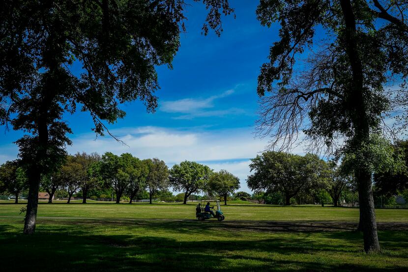 A golfer drive a cart along a fairway at Golf Club of Dallas on Wednesday, April 1, 2020, in...