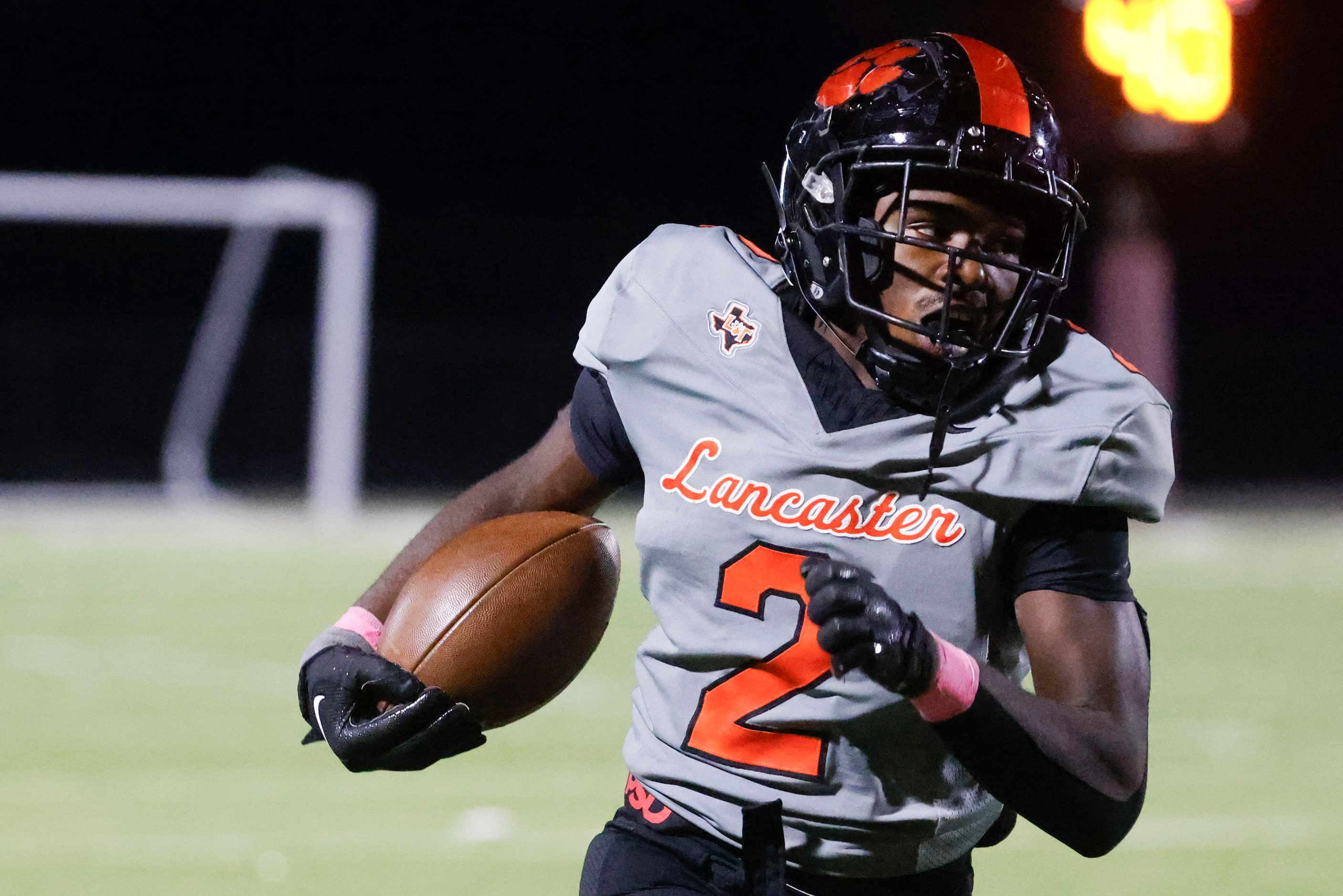 Lancaster High’s Izayah Lee (2) runs the ball for a yardage during the second half of a...