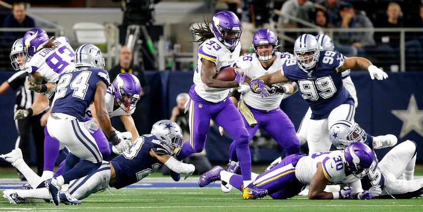 Minnesota Vikings running back Dalvin Cook (33) finds a hole in the Dallas Cowboys defines...