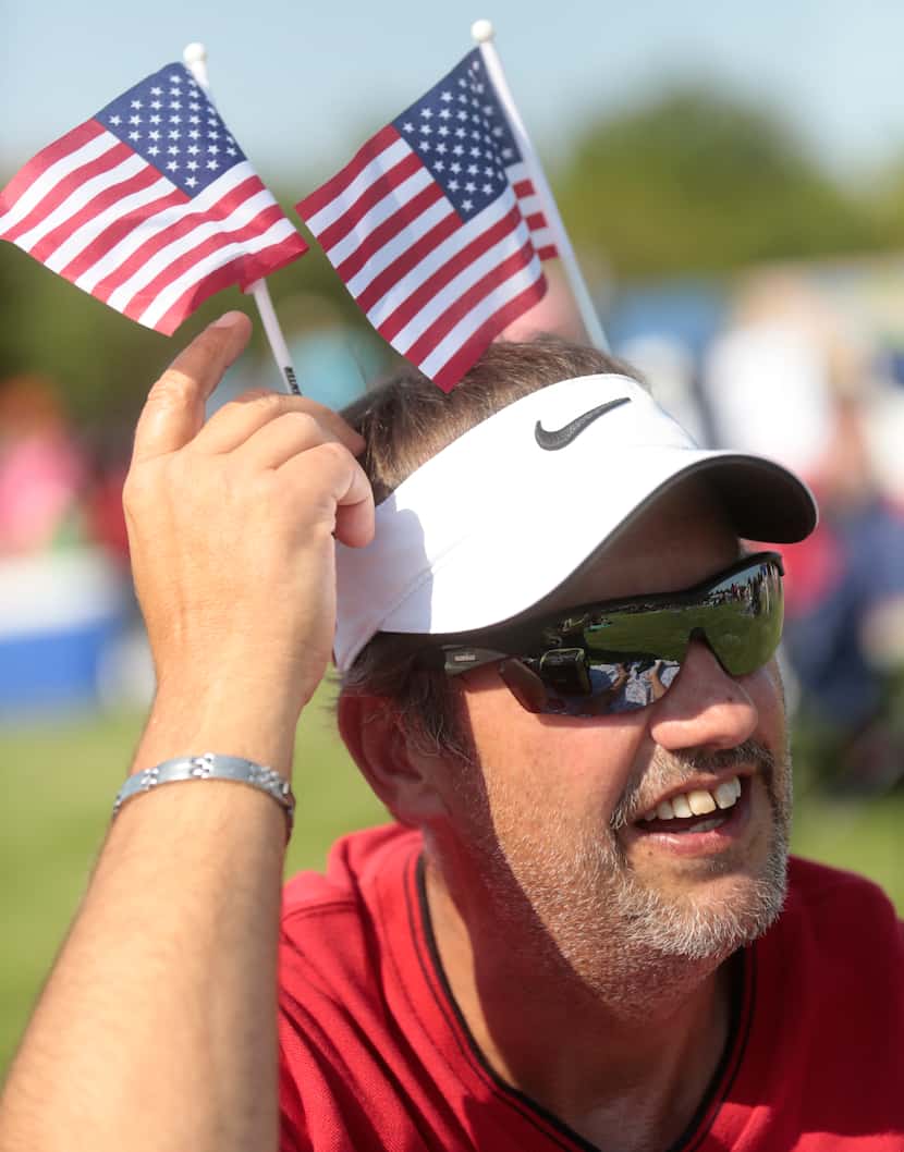 Michael Neumann of  Garland, adjusts some decorative U.S. flags during the Kaboom Town -4th...