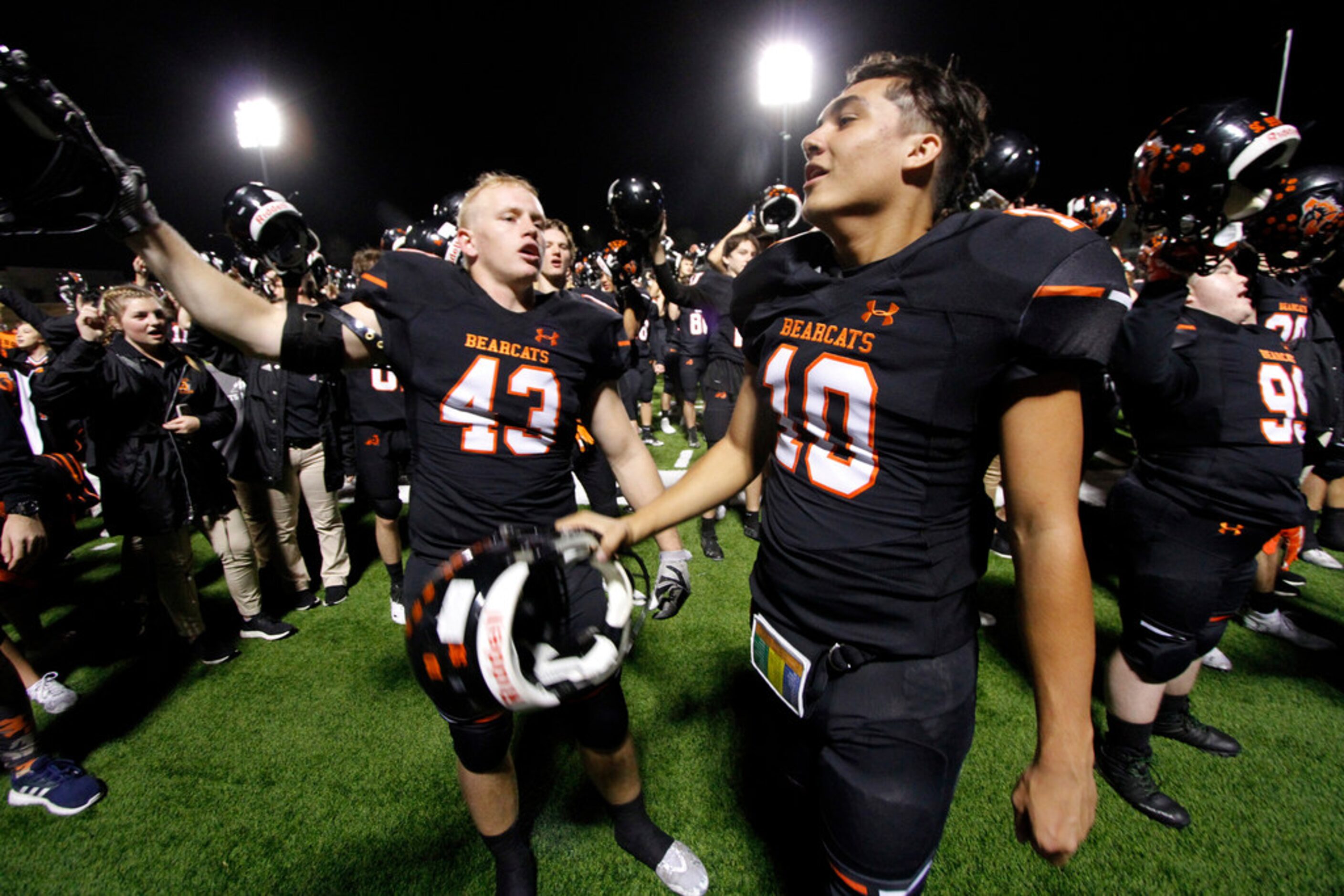 Aledo Bearcats players celebrate at midfield following the playing of the school song and...