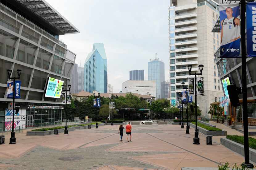 People walk through Victory Park at American Airlines Center in Dallas. Dallas County is...