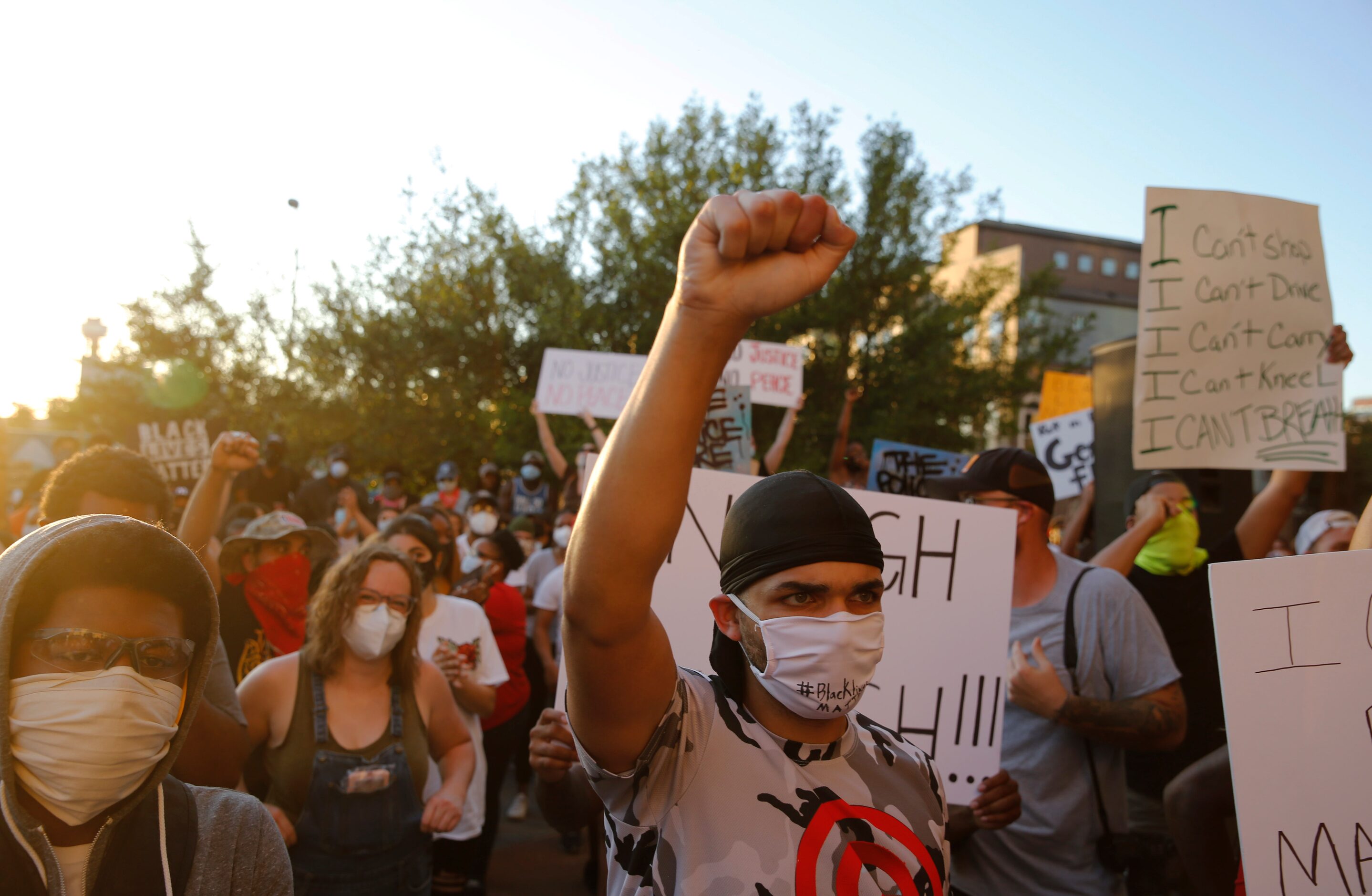 Protesters kneel as Texas Senator Royce West asks people to kneel as he speaks during a...