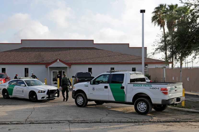 FILE - In this June 23, 2018 file photo, a U.S. Border Patrol Agent walks between vehicles...