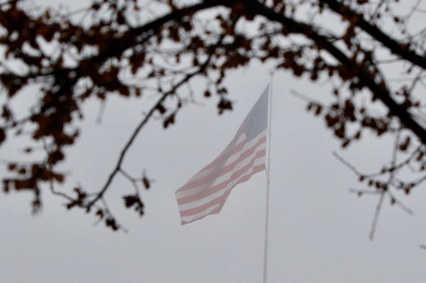 An American flag blows in a thick fog on Tuesday morning near downtown Dallas on January 9,...