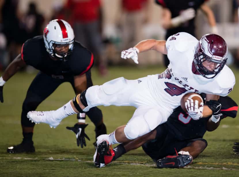 Rowlett running back Anthony Wagner is tackled by two Lake Highlands players in last week's...