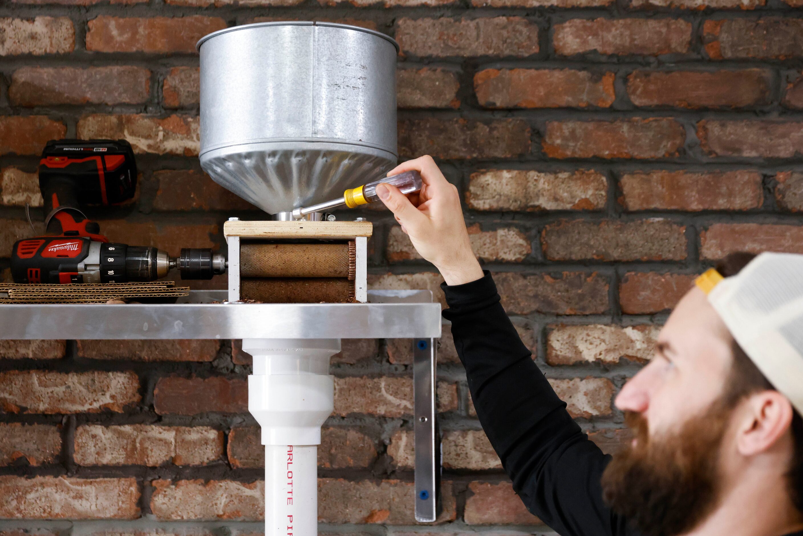 Deric Cahill points towards a winnower that he uses to separate cacao from the chaff in his...