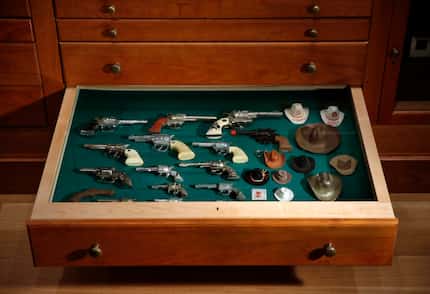 Toy cowboy guns and hats occupy one drawer of the "Texas Cabinet."