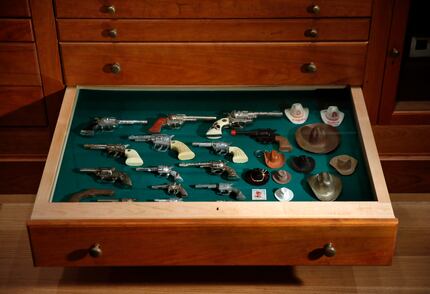 Toy cowboy guns and hats occupy one drawer of the "Texas Cabinet."