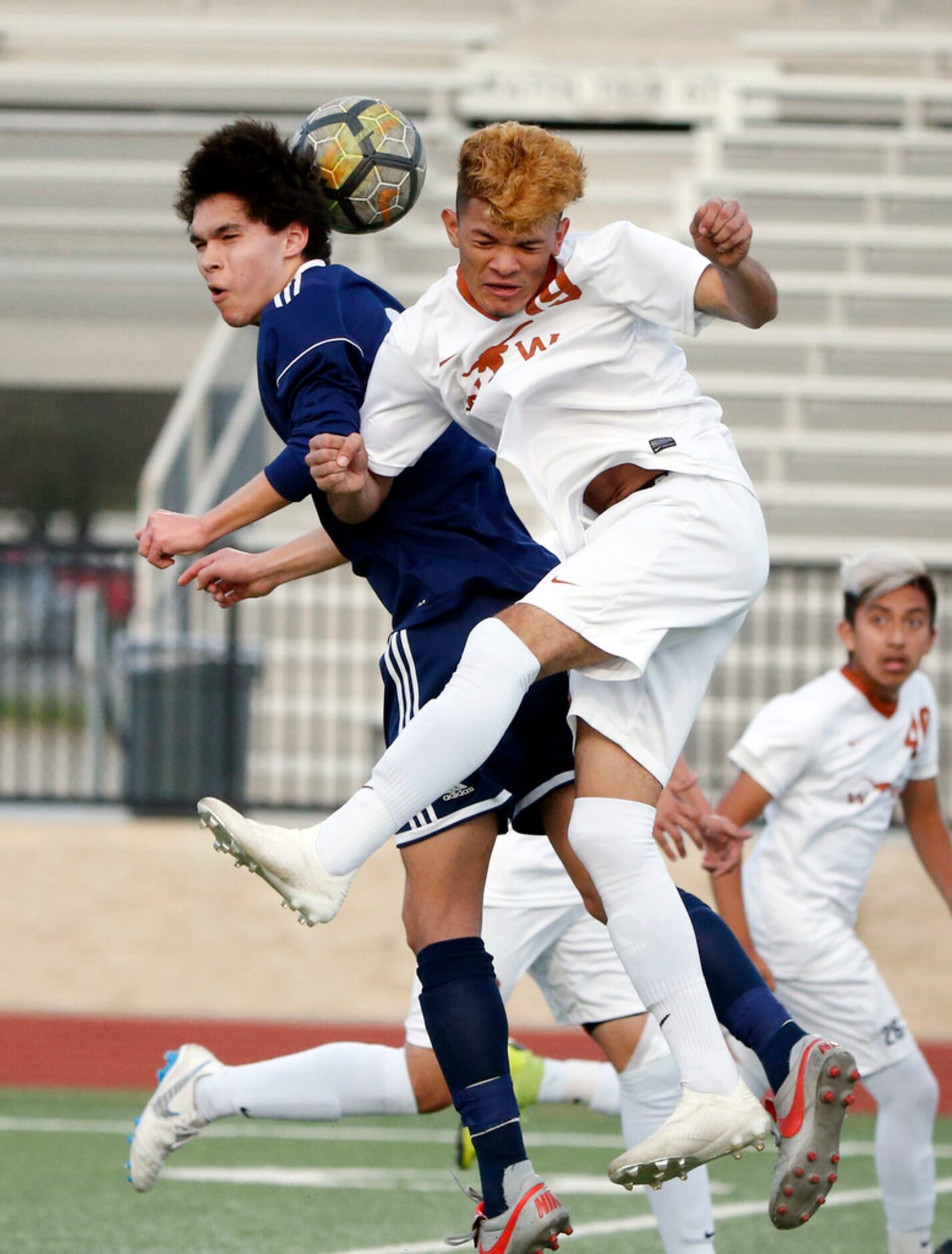 Flower Mound's Niko Zeppenfeld, left, and W.T. White's Juan Zambrano (19) go for a header...