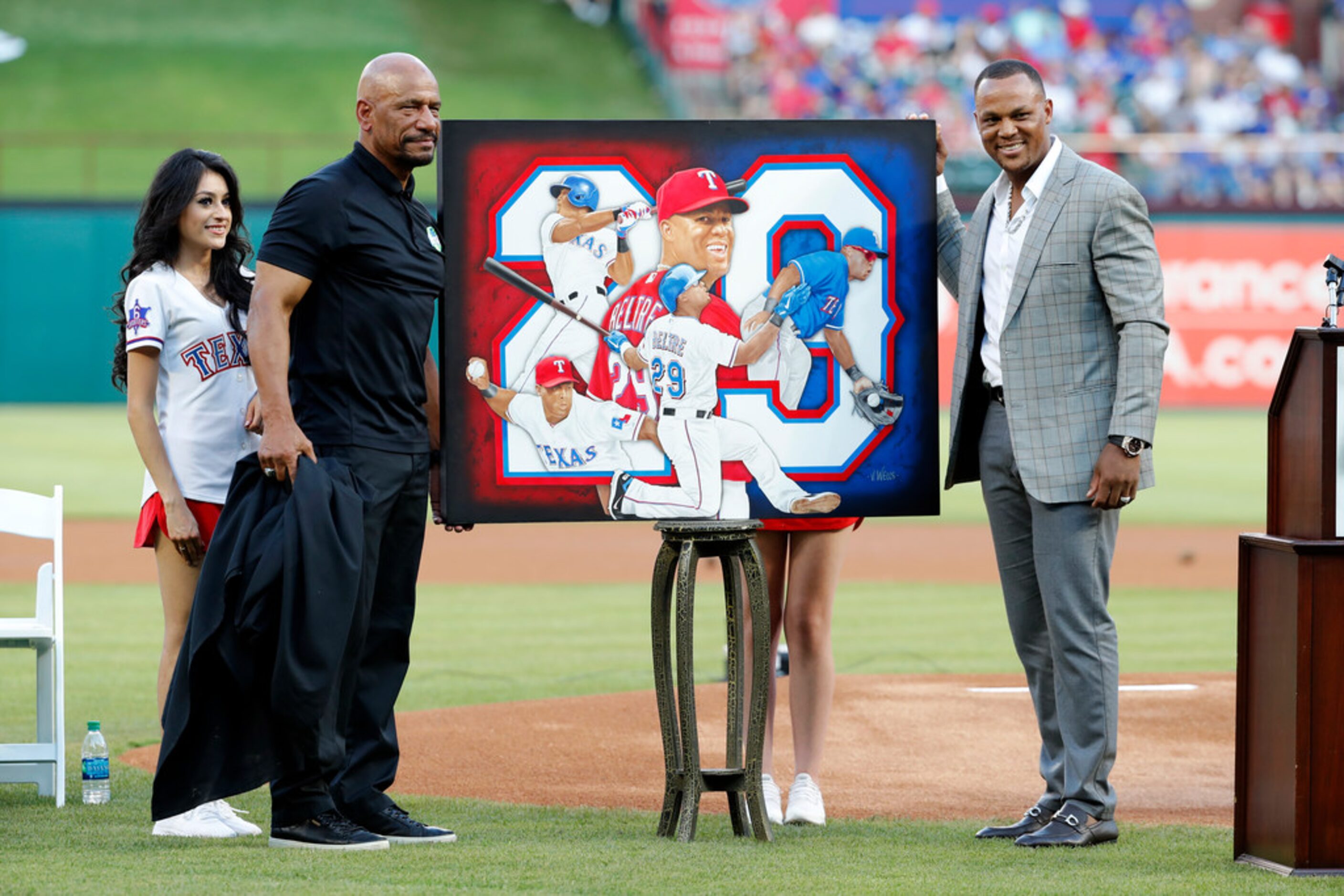 Artist Vernon Wells, left, presents former Texas Rangers player Adrian Beltre, right, with a...