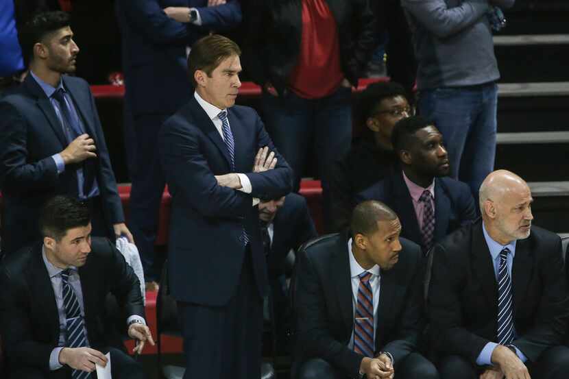 Southern Methodist Mustangs head coach Tim Jankovich, second from left, looks onto the floor...