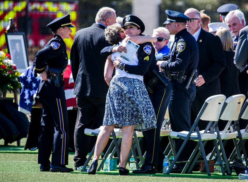  Officers, family and friends of Euless police officer David Hofer hug during a memorial...