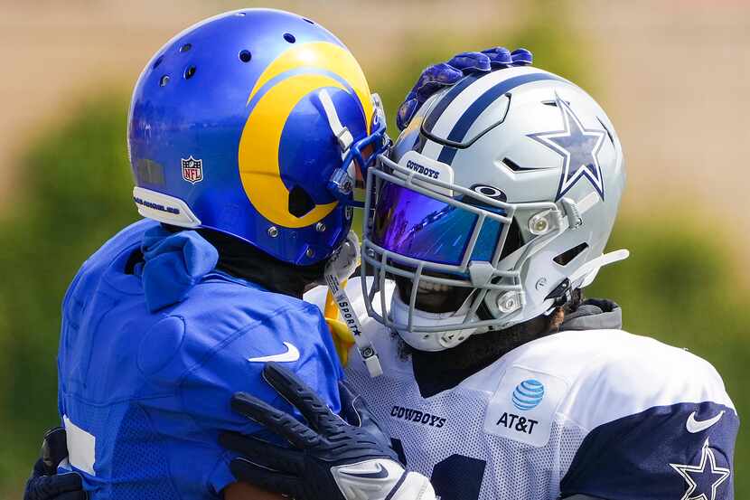 Dallas Cowboys running back Ezekiel Elliott (21) hugs Los Angeles Rams cornerback Jalen...