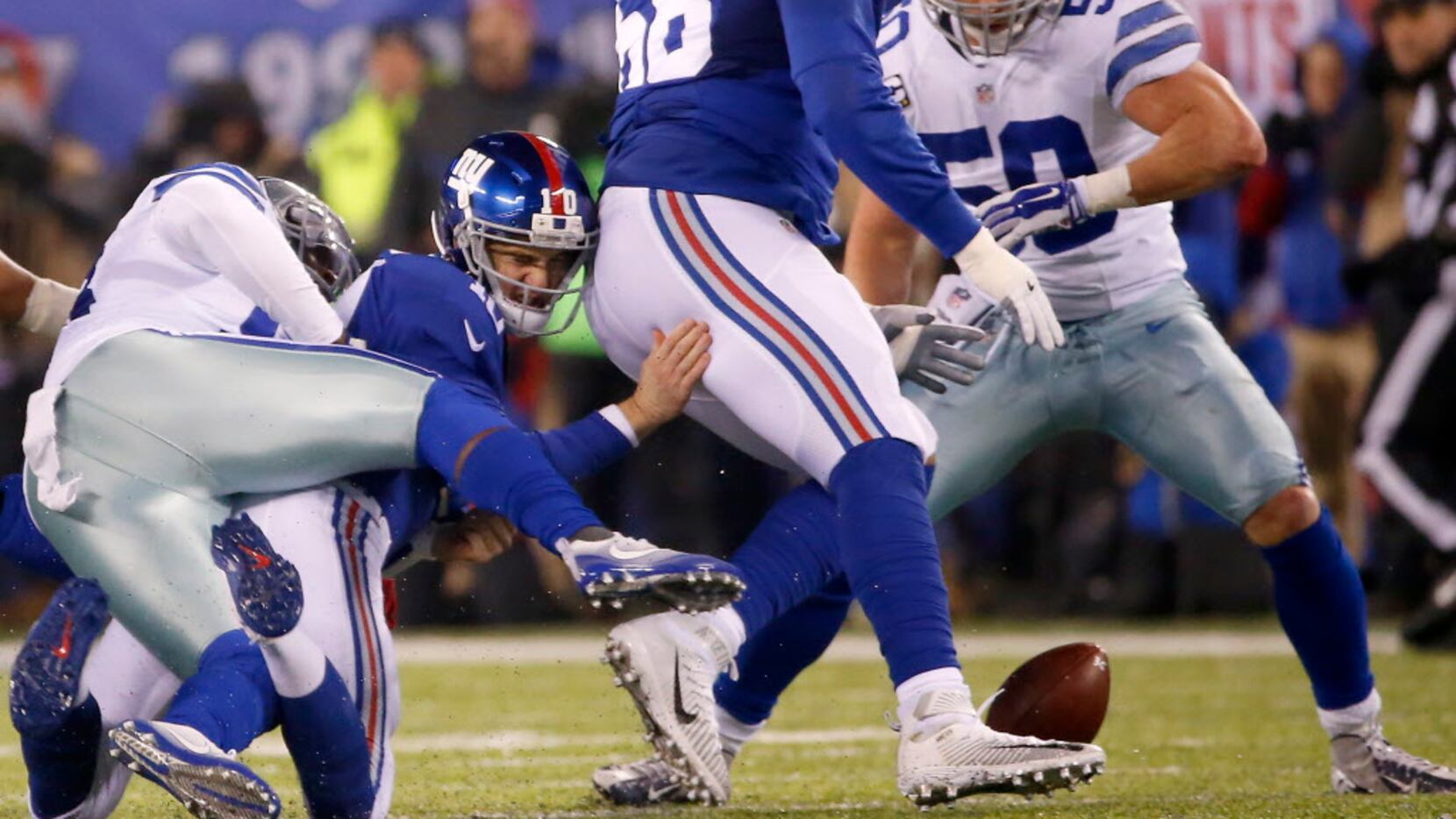 New York Giants quarterback Eli Manning (10) fumbles the ball as he's tackled by Dallas...