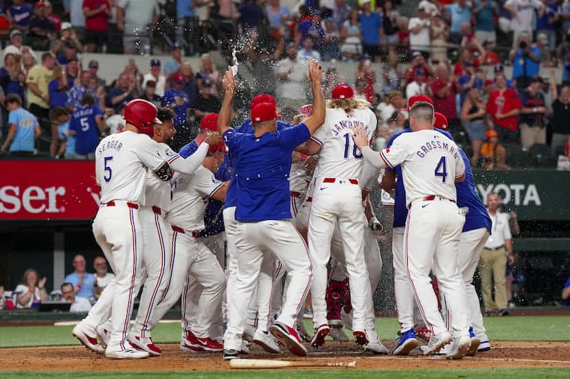 The Texas Rangers celebrate at home plate after Josh Smith hit a two-run walkoff home run...