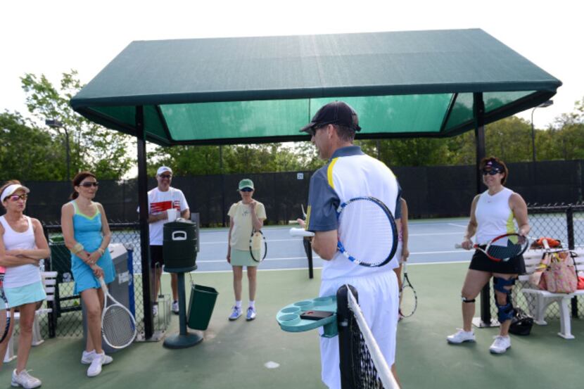 Chris Wade, athletic instructor at the T Bar M Racquet Club speaks to tennis players before...