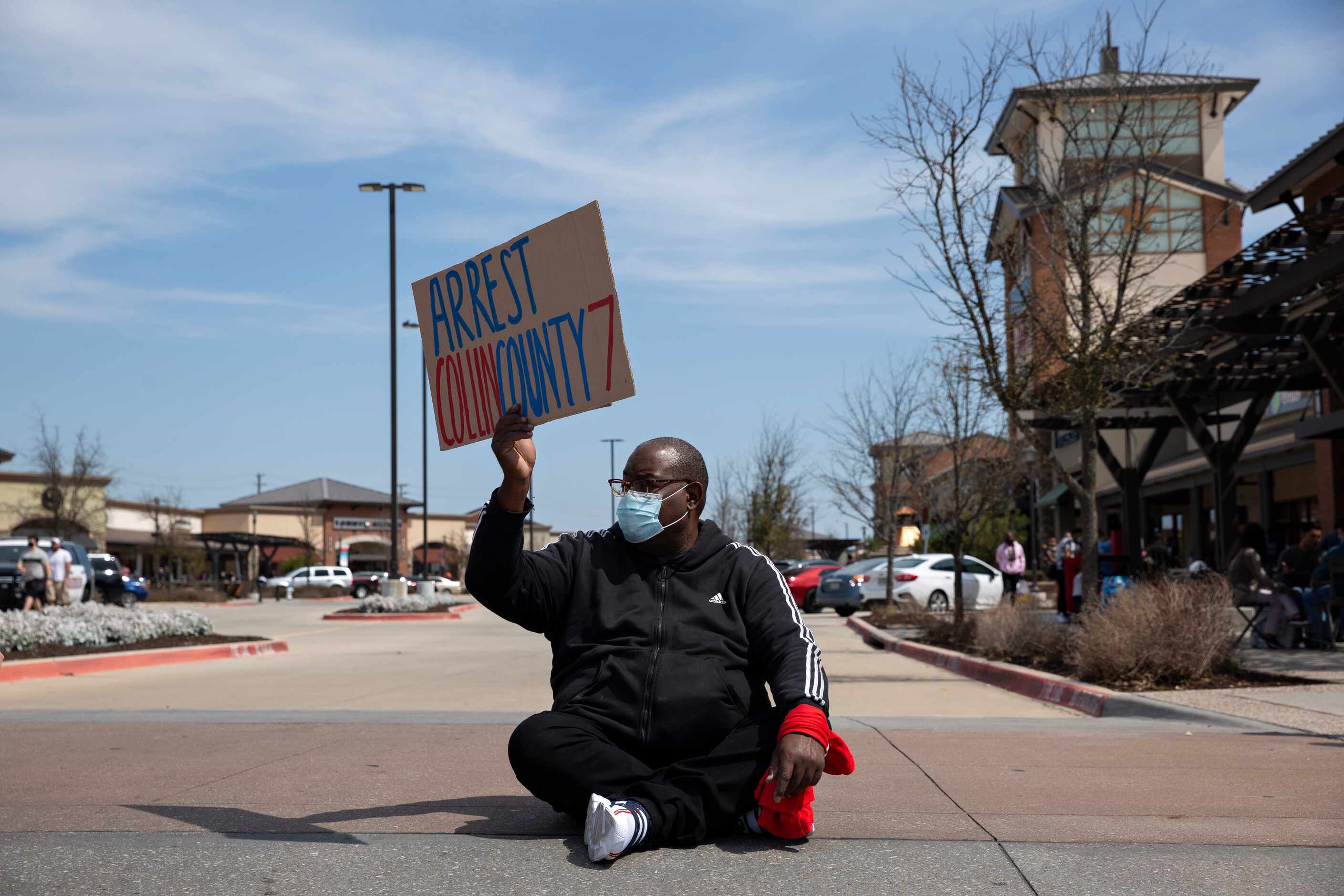 Marvin Scott Jr. sits in the road with other demonstrators to block traffic in the Allen...