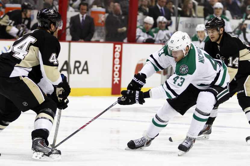 Valeri Nichushkin #43 of the Dallas Stars handles the puck in front of Brooks Orpik #44 of...