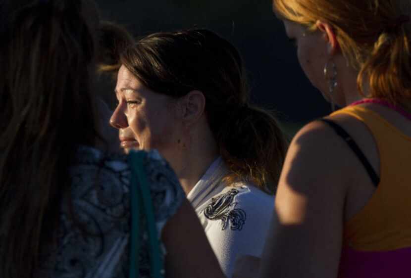 A woman cries outside Gateway High School where witness were brought for questioning after a...
