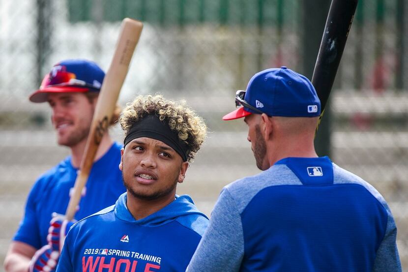 Texas Rangers outfielder Willie Calhoun talks with manager Chris Woodward between rounds of...