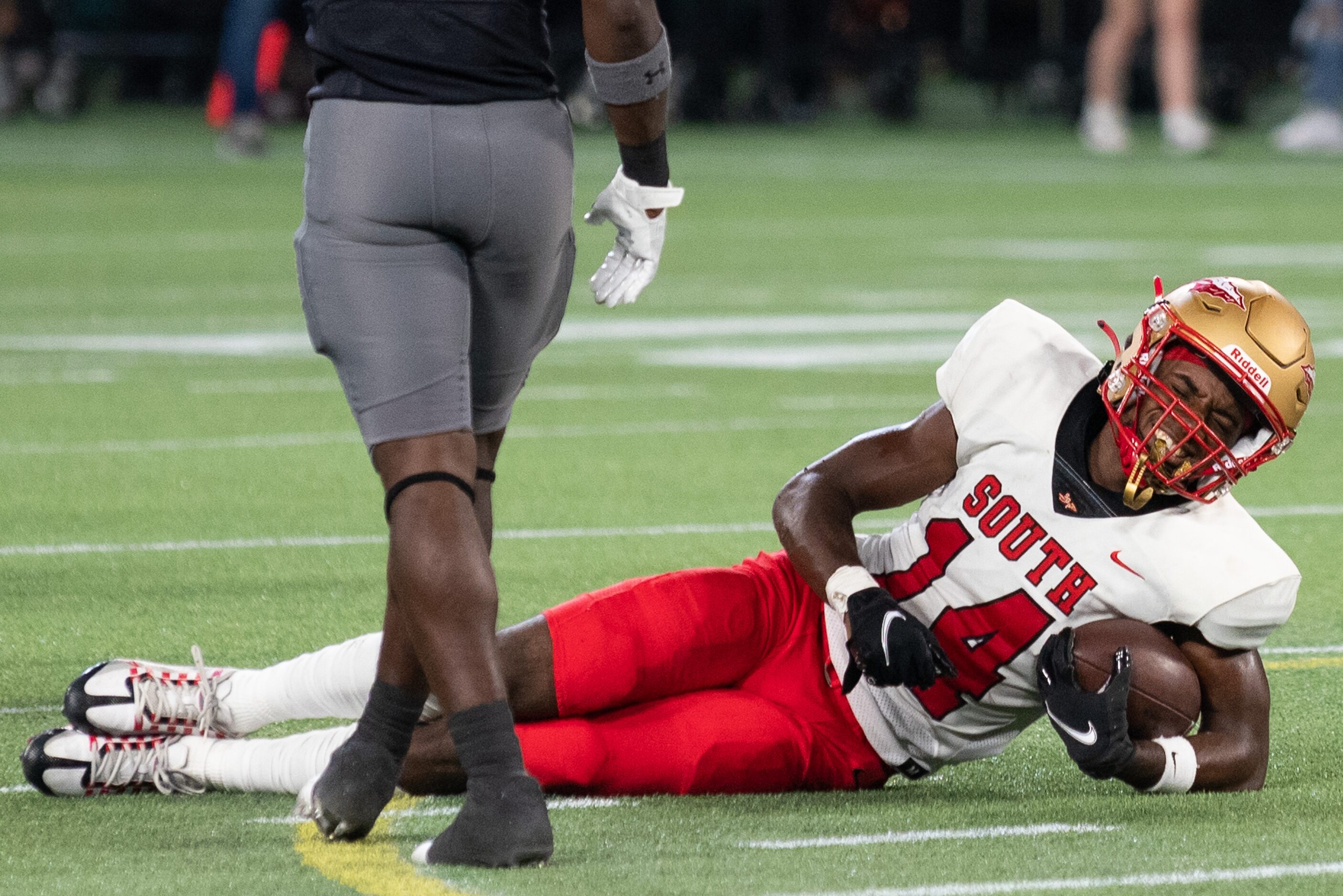 South Grand Prairie senior wide receiver Julian Stratford (14) reacts with pain after being...