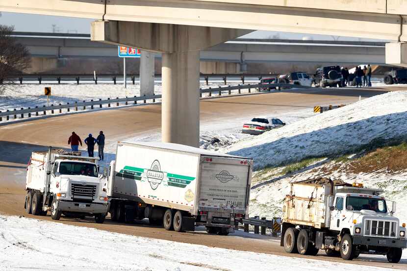 On a snowy day in March 2015, Texas Department of Transportation sanding trucks lay down a...