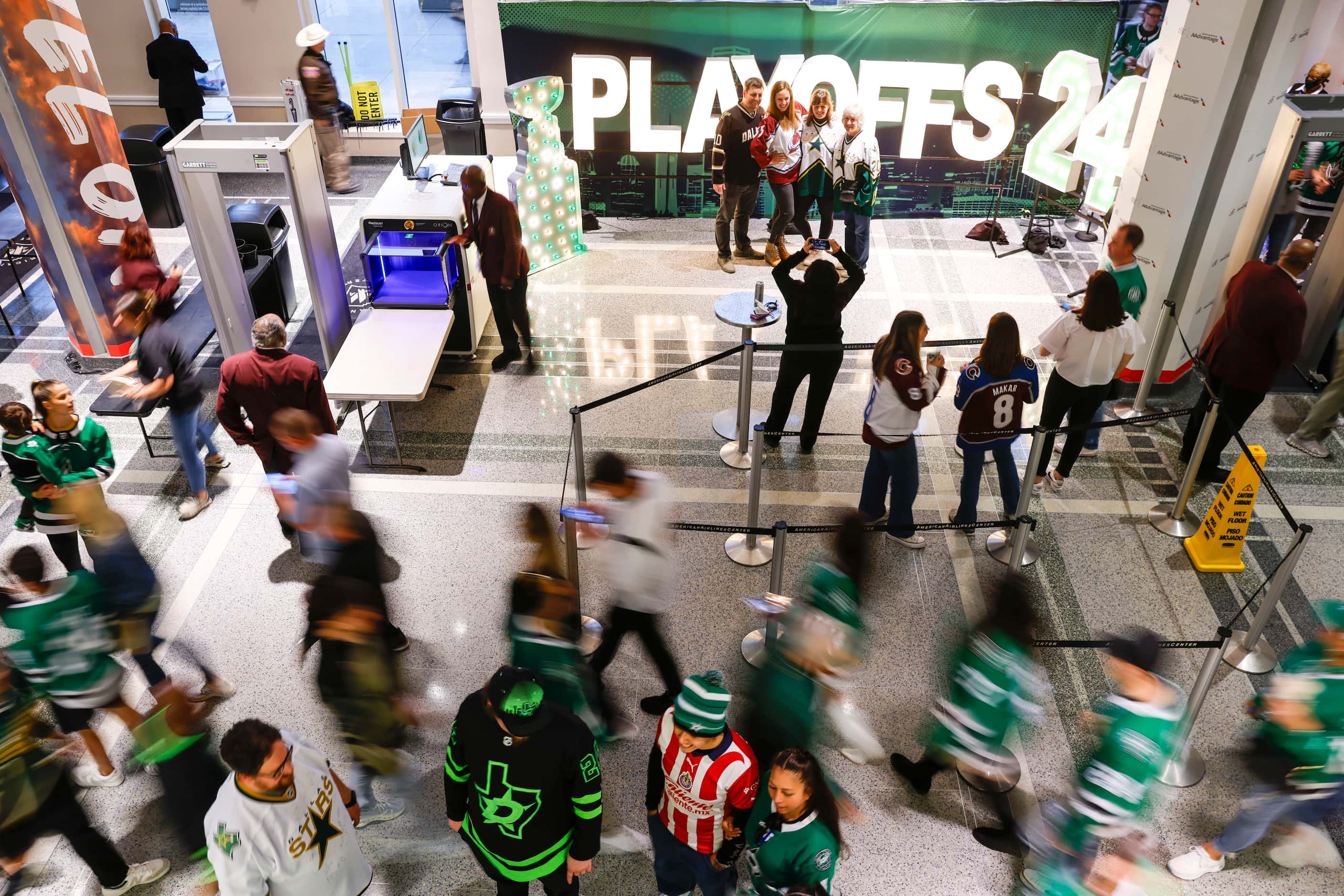 Fans pose for photos in front of a sign as others cruises through the concourse ahead of...