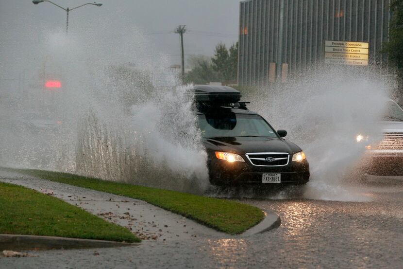 Cars plowed through flooded roads on Lemmon Avenue during torrential rains in Dallas....