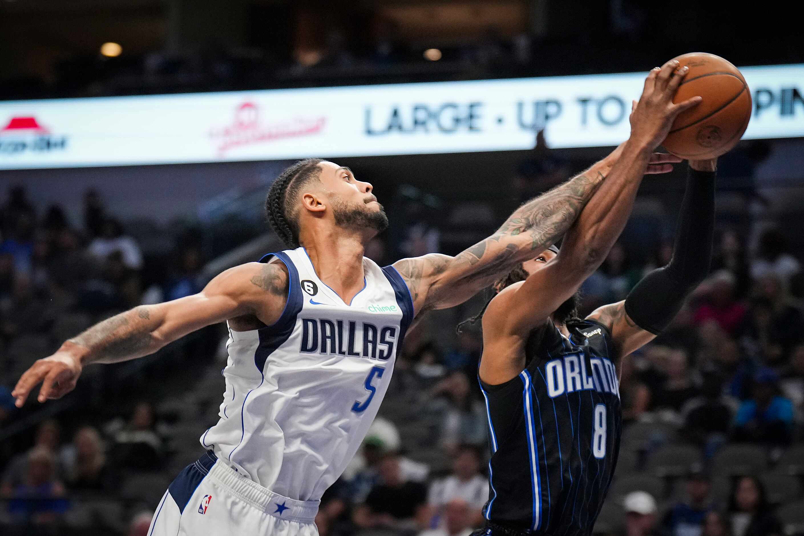Dallas Mavericks guard Tyler Dorsey (5) fights for a rebound against Orlando Magic guard...