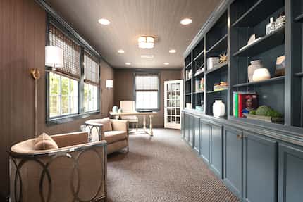 Office with built-in bookshelves and cabinets and a seating area.