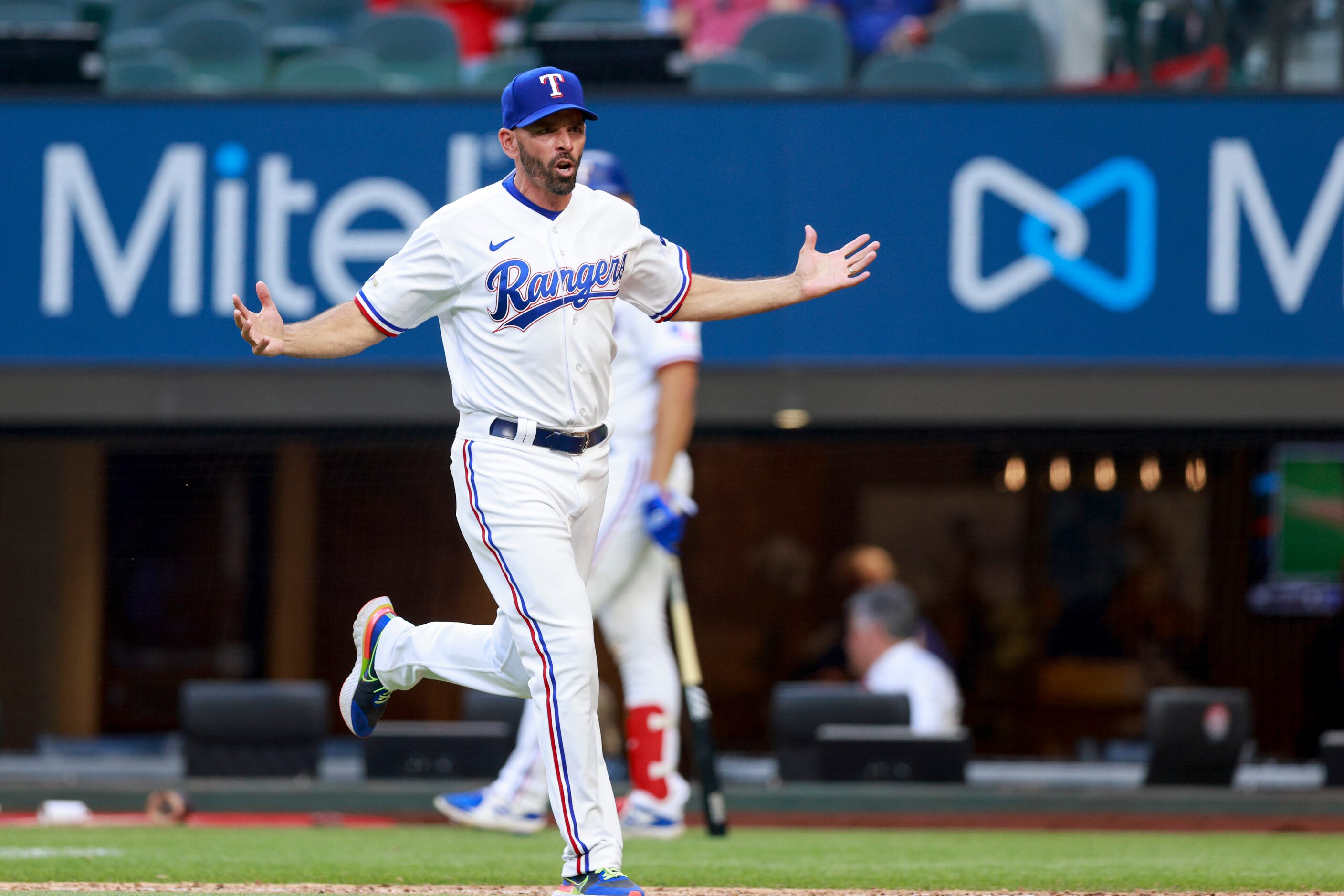 Texas Rangers manager Chris Woodward (8) runs onto the field to argue an overturned call...