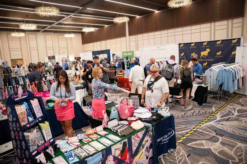 Attendees and exhibitors browse the booths at a three-day PGA Buying and Education Summit at...