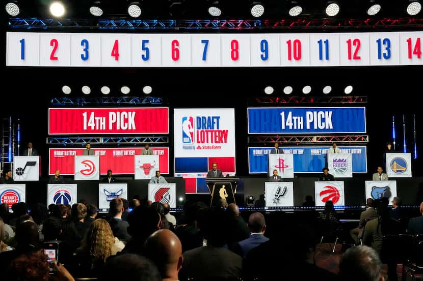 NBA Deputy Commissioner Mark Tatum, center, announces the 14th pick in the NBA draft, during...