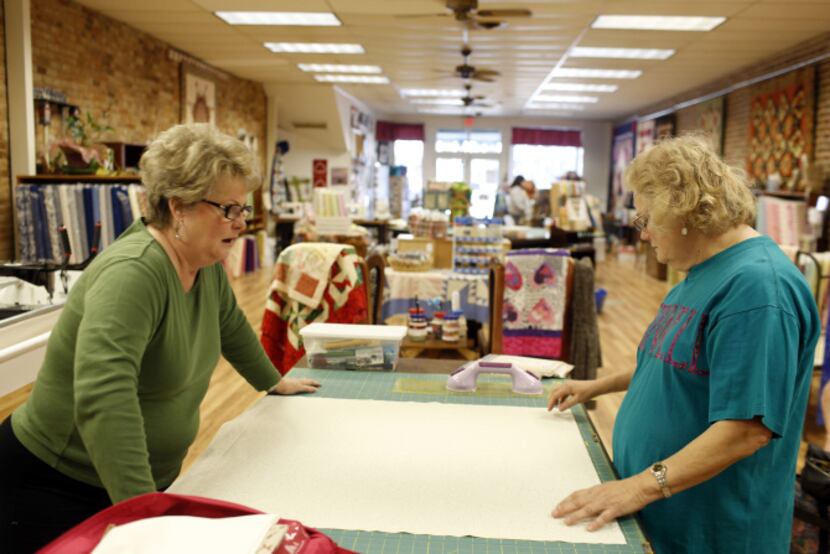 Laura Murrey (left) and Cynthia McLelland lay out part of a quilt during a class in Kaufman....