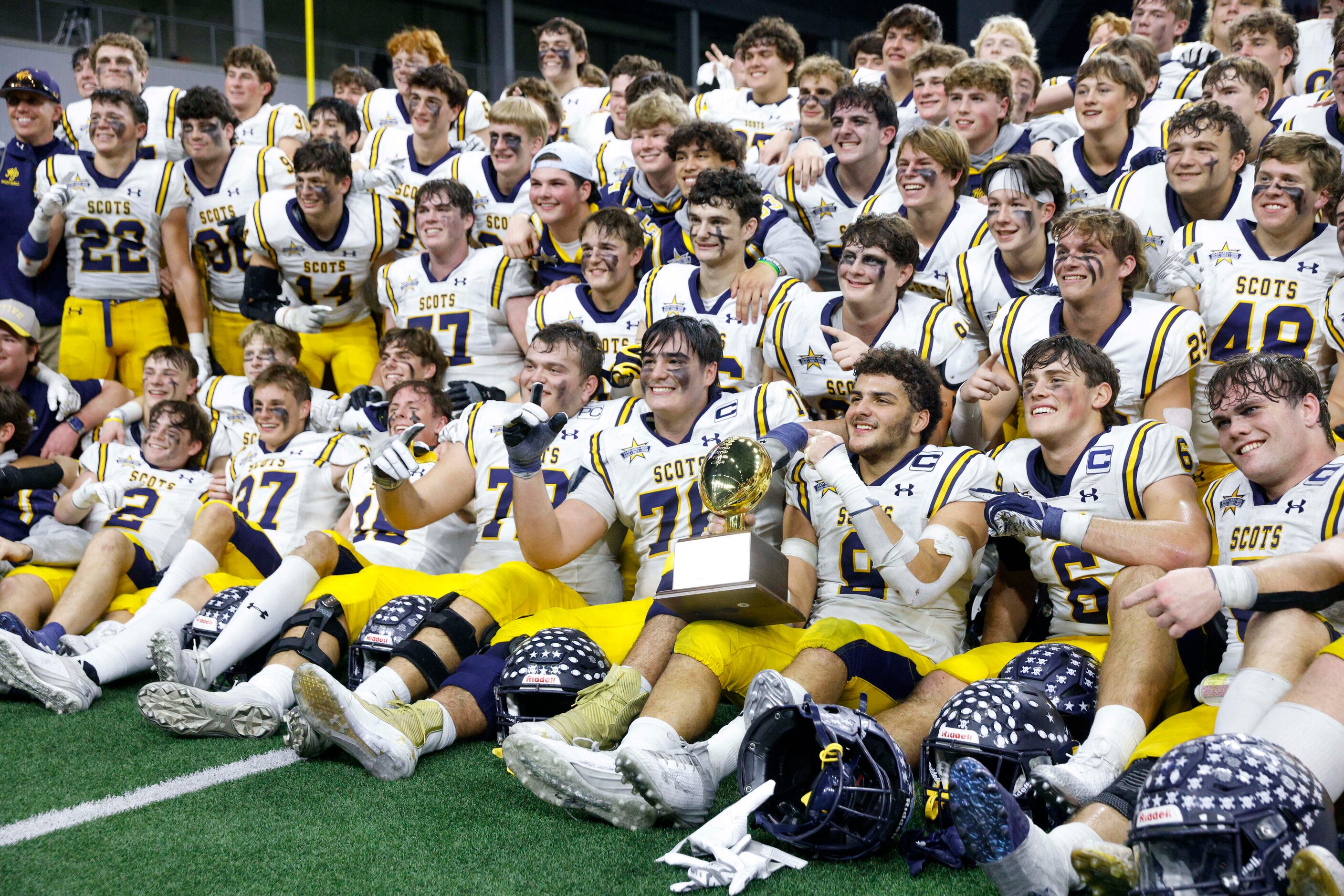 Highland Park players pose with a Class 5A Division I state semifinals championship trophy,...