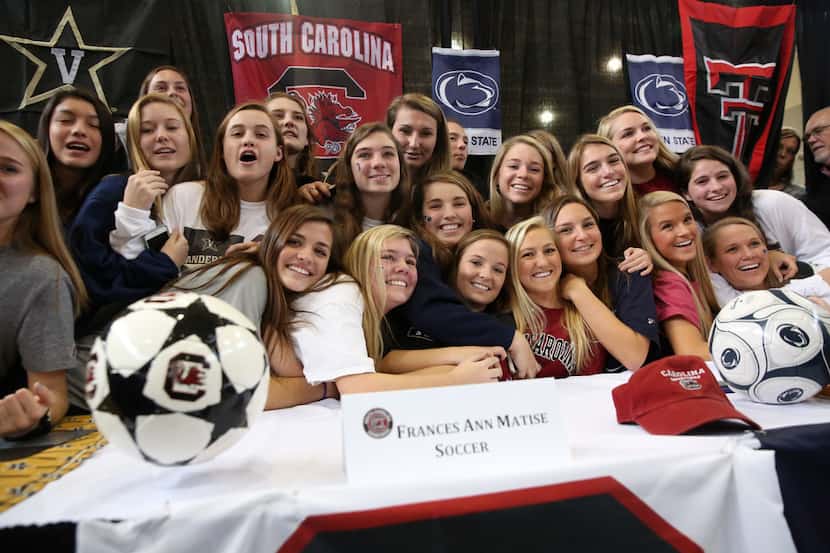 The Highland Park girls soccer team poses for a photograph with the four signees during a...