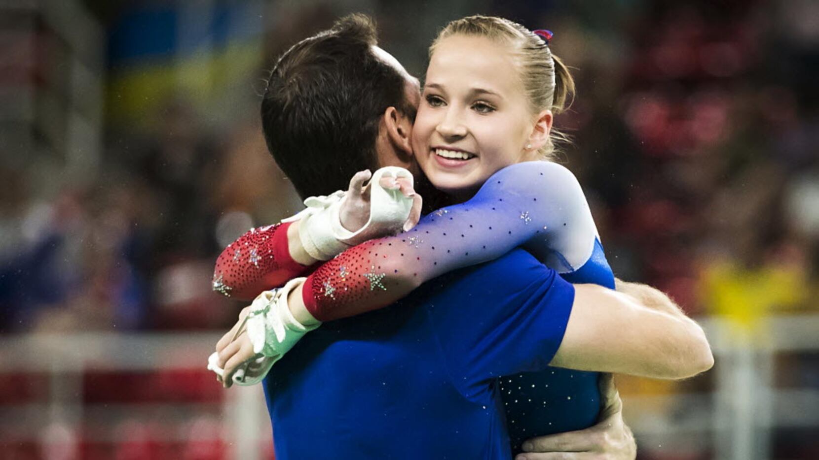 Madison Kocian of the United States celebrates with coach Laurent Landi after her routine on...