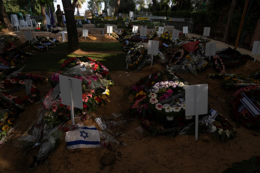 Una bandera israelí yace junto a flores sobre la tumba de un soldado muerto en la guerra...