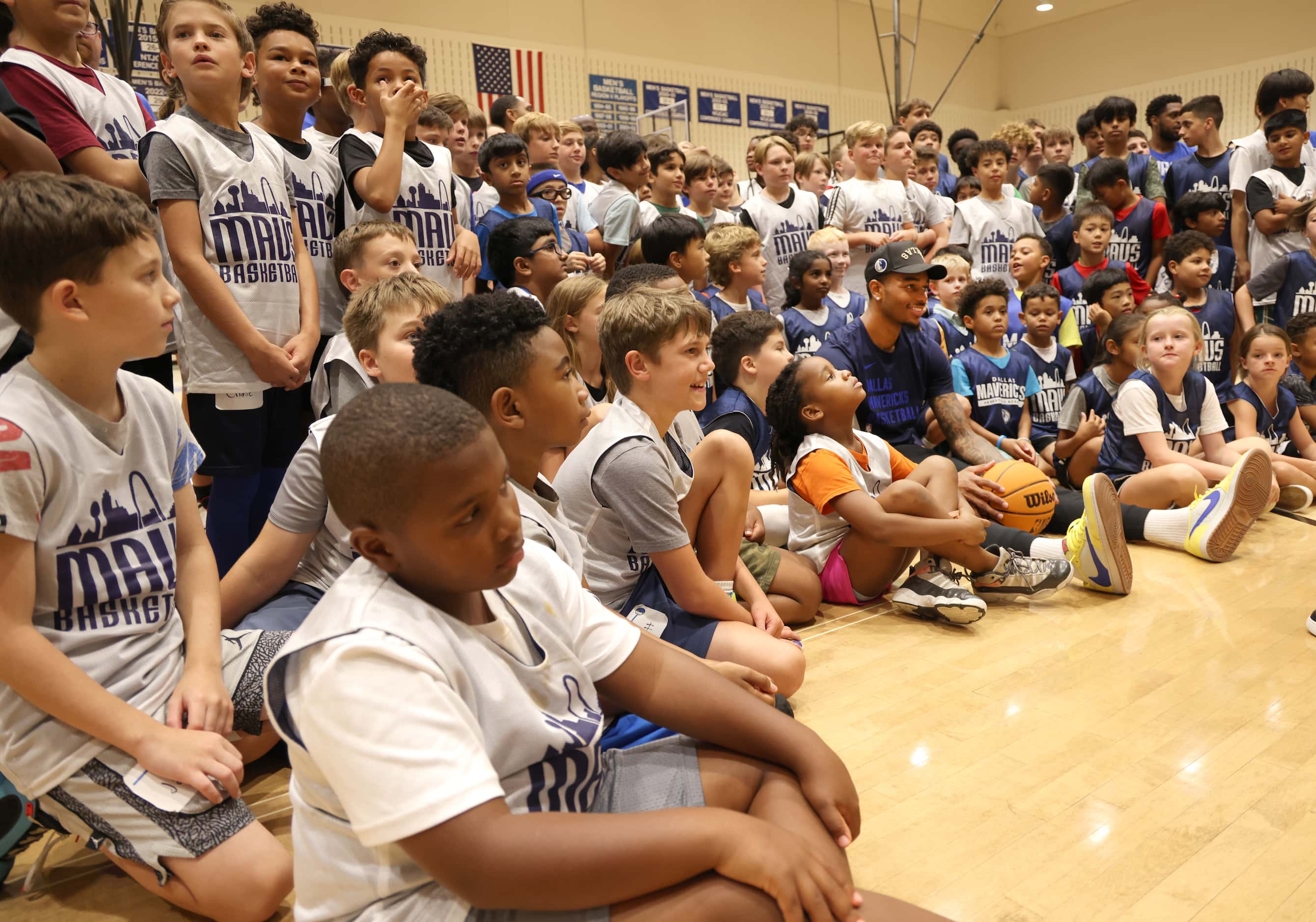Dallas Mavericks forward and center PJ Washington, center right, is surrounded by Hoop Camp...