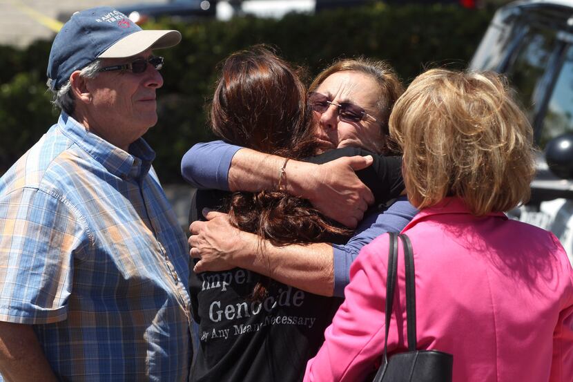 Members of the Chabad synagogue hug as they gather near the Altman Family Chabad Community...