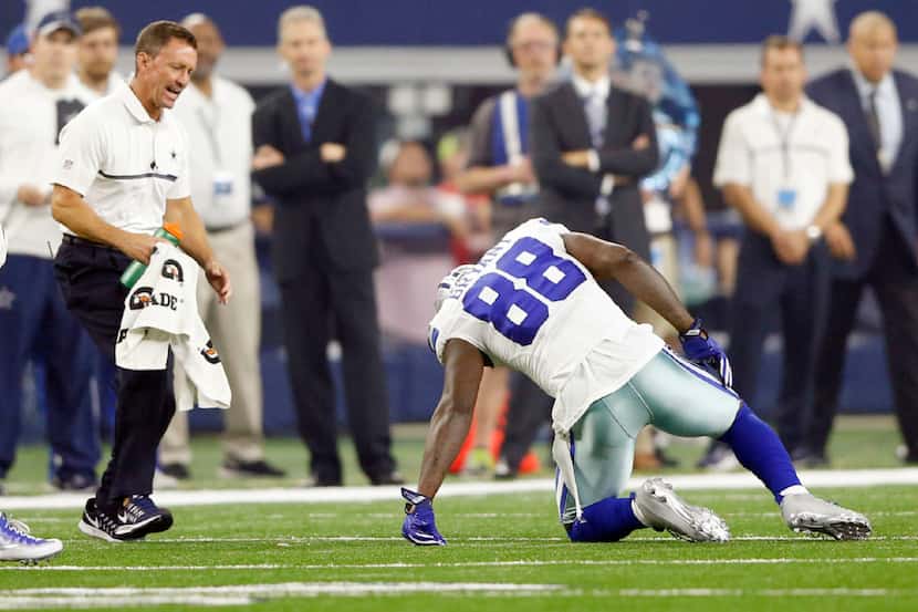 Dallas Cowboys athletic trainer Britt Brown comes to the aid of Dallas Cowboys wide receiver...