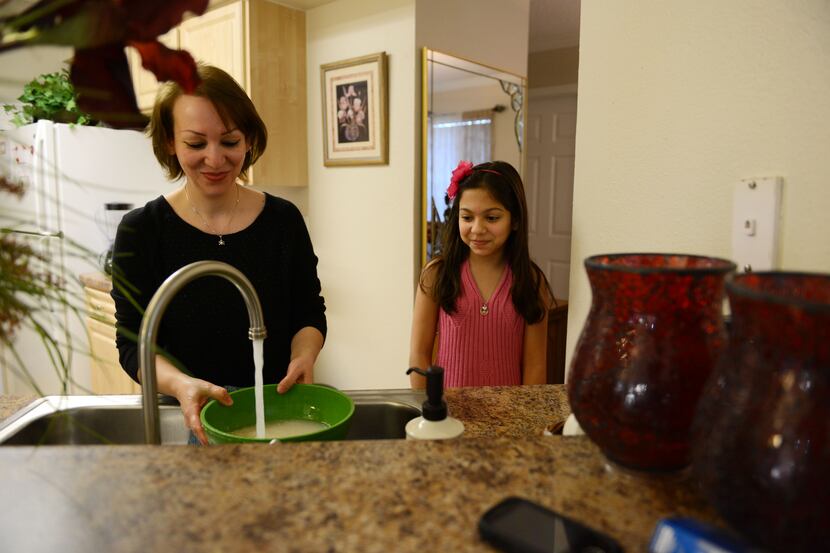 Rojan Nobari, 10, watches her mother Rozita cook dinner at the family's Plano apartment. The...